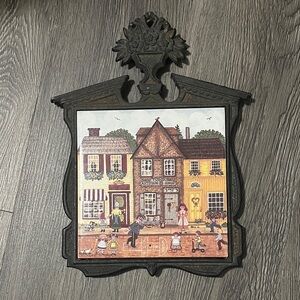 Vintage iron trivet with Village Scene tile